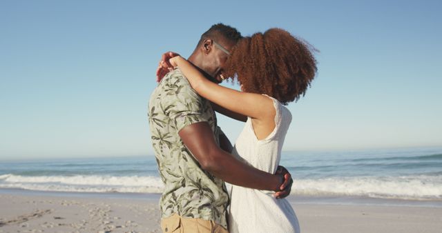 Happy diverse couple embracing on sunny beach by the sea - Download Free Stock Photos Pikwizard.com