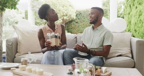Joyful couple exchanging gifts in a festive atmosphere