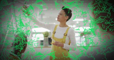 Leader Placing Sticky Notes on Glass Board with Green Augmented Data Overlay