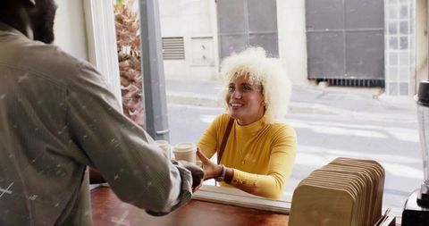 Happy Customer Receiving Coffee at Open Service Window in Cozy Cafe