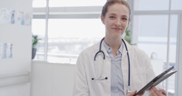 Confident Female Doctor Holding Digital Tablet in Modern Clinic - Download Free Stock Images Pikwizard.com