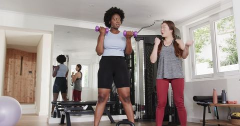 Diverse Women Engaging in Fitness Training with Dumbbells