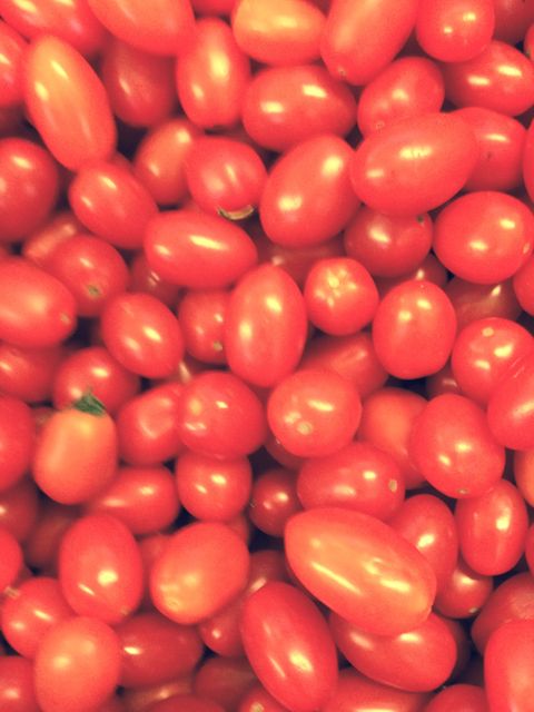 Close-up view of many ripe red grape tomatoes filling the frame. Ideal for use in food blogs, dietary content, recipe illustrations, or as an image representing healthy eating and fresh produce markets.