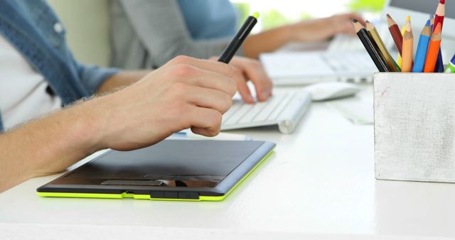 Hands Using Digital Tablet Stylus Near Desk With Pencils and Keyboard - Download Free Stock Images Pikwizard.com