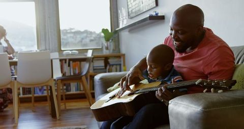 Father Teaching Son to Play Guitar at Home on Sofa - Download Free Stock Images Pikwizard.com