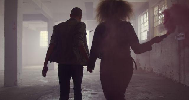 Back View of Couple Holding Hands with Smoke Bomb in Abandoned Warehouse - Download Free Stock Images Pikwizard.com