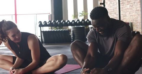 Diverse Friends Stretching in Modern Fitness Studio