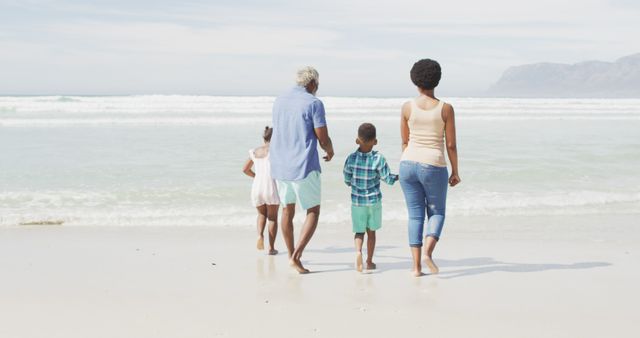 African american couple walking with children on sunny beach. healthy and active time beach holiday.