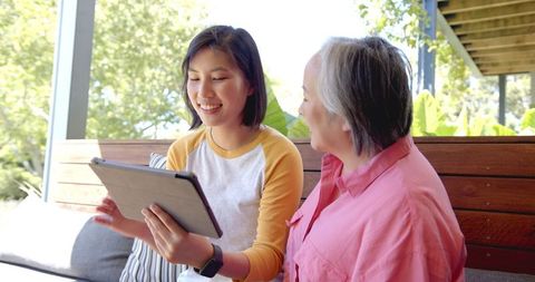 Smiling Women Using Tablet Outdoors, Technology and Family Bonding