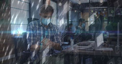 Masked professional at office desk with technology overlay