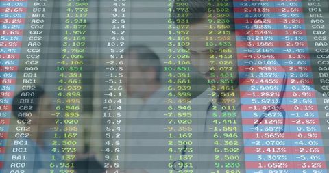 Traders Studying Market Data Through Glass Ticker, Collaborating on Financial Analysis