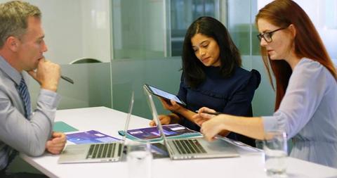 Three Colleagues in Business Meeting Collaborating with Laptops and Tablet - Download Free Stock Images Pikwizard.com