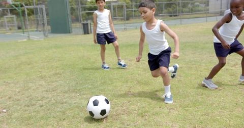 Boys in Uniform Enjoying Soccer Game on Grass Field