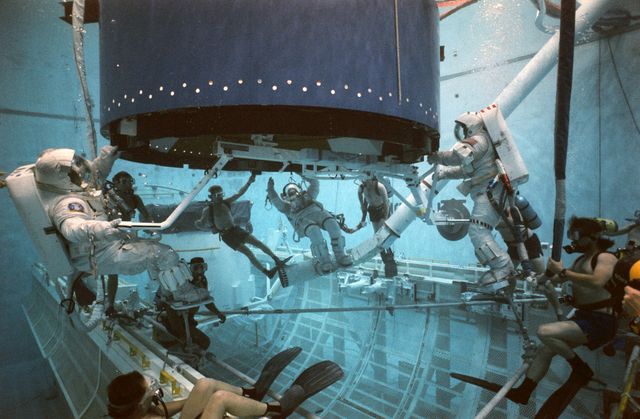 S92-35764 (12 May 1992) --- Wearing extravehicular mobility units (EMU's) and fitted with weights for neutral buoyancy are three trouble-shooting astronauts.  The astronauts practiced techniques for capturing Intelsat, and climbing into the airlock mockup in the Weightless Environment Training Facility (WETF).  No apparent problems were identified in placing three astronauts in the airlock at one time.  Left to right are, Michael R. (Rich) Clifford, Story Musgrave, and James S. Voss.  Three Endeavour astronauts, Pierre J. Thuot, Richard J. Hieb and Thomas D. Akers, will attempt to capture Intelsat again on May 13.  Clifford played the role of Hieb, Musgrave for Thuot, and Voss, Akers.