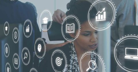 Mid-adult woman reviewing analytics on computer with floating digital icons for teamwork