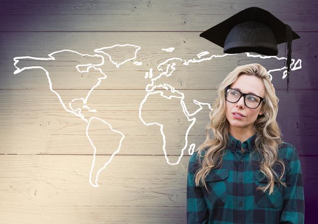 Thoughtful woman in spectacle and mortarboard above head against world map on wooden background