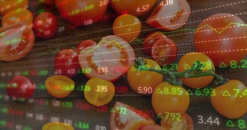 Fresh red and yellow cherry tomatoes halved on dark wood with stock market overlay