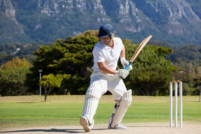 Cricket Player Batting on Field with Mountain View - Download Free Stock Photos Pikwizard.com
