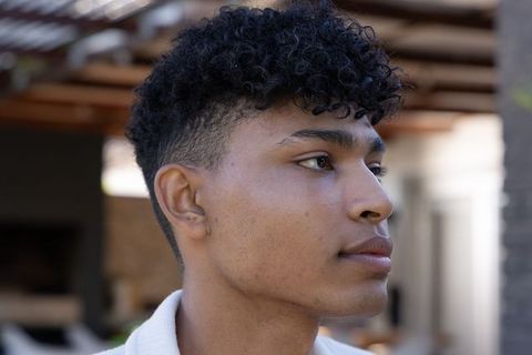 African american young man outdoor headshot profile under wooden pergola natural light