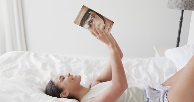 Woman Relaxing on Bed Reading Book in Bright Bedroom - Download Free Stock Images Pikwizard.com