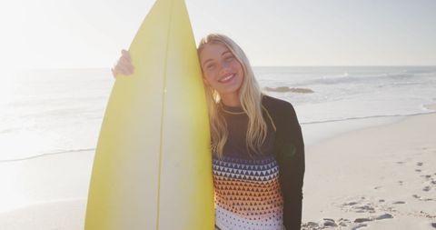 Smiling Woman Holding Surfboard on Sunny Beach
