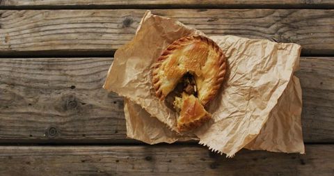 Savoury mini pie on rustic wrapping with weathered wooden background