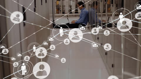 Technician Using Laptop in Server Room with Network Graphics