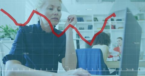 Businesswoman analyzing data with financial graph overlay in modern office