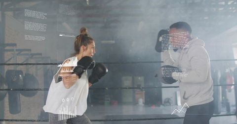 Woman sparring with coach in boxing ring with augmented hud performance data