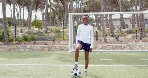 Young Athlete Balancing Soccer Ball on Football Field