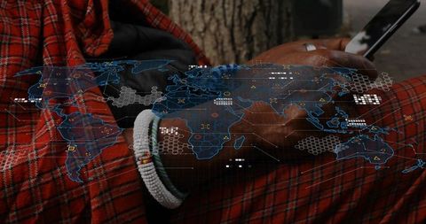 Tapping smartphone with beaded bracelet and red plaid cloth, global map overlay and data