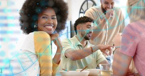Smiling black woman enjoying casual breakfast with friends while teal dna helix overlay