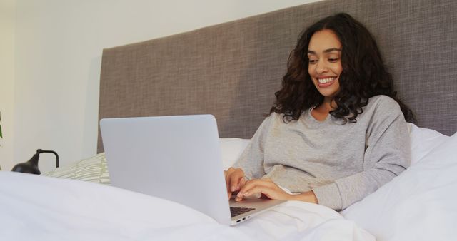 Smiling Woman Working on Laptop in Bed at Home - Download Free Stock Images Pikwizard.com