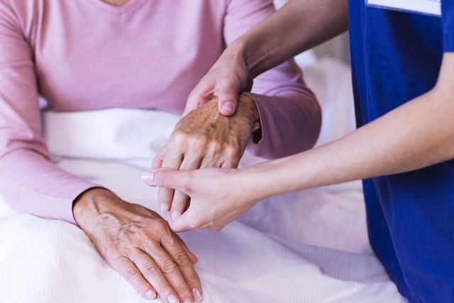 This image depicts a physiotherapist examining the hand of a senior patient. It is ideal for use in healthcare, medical services, elderly care, and rehabilitation contexts. Suitable for illustrating patient care, physical therapy, and hospital environments.