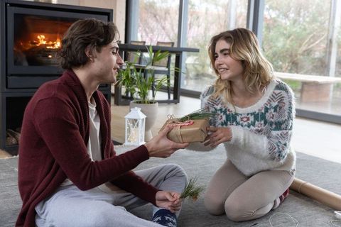 Romantic gift exchange by fireplace in cozy home