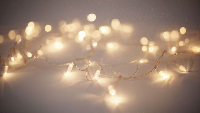 Warm white led string lights creating soft bokeh glow on neutral surface