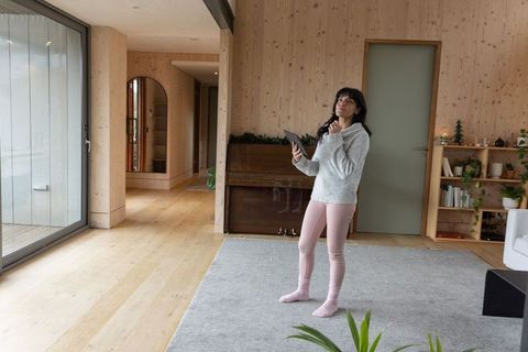 Asian Woman with Tablet in Minimalist Wooden Living Room