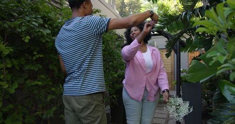 Happy Couple Dancing in Lush Garden Outdoors