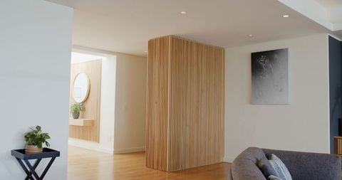 Vertical wooden slat divider separating living area and entry, modern minimal interior