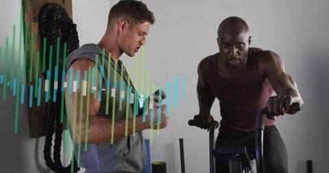 Trainer coaching high-intensity indoor cycling sprint with digital timer and performance metrics