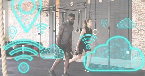 Two adults performing kettlebell lunges in industrial gym with cloud and wi-fi overlays