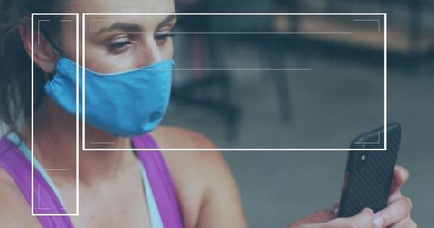 Woman in Face Mask Using Smartphone at Gym