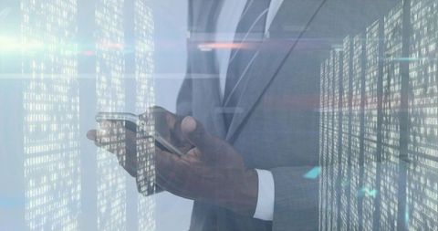 Executive tapping smartphone while reviewing holographic data columns and digital analytics