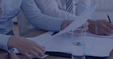 Business Professionals Reviewing Documents and Taking Notes in Boardroom with Digital HUD
