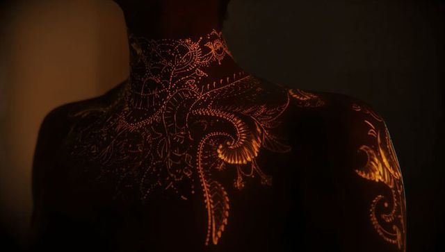 Luminous ornamental body art on female torso