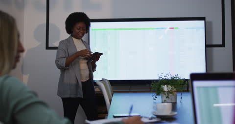Professional Executive Presenting Financial Data to Colleagues in Modern Office
