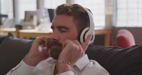 Creative Professional Listening to Music in Modern Office Lounge