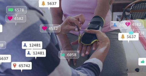 Caregiver fastening wrist brace on senior at home with social media notification overlays