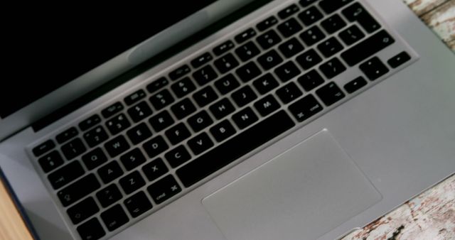 Perfect for illustrating articles, blogs, and websites about technology, modern workspaces, remote work, and productivity tools. This image highlights the sleek design of an open silver laptop on a rustic wooden table, providing an aesthetically pleasing and professional look for digital and print publications.