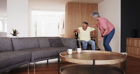 Senior couple navigating mobility aid in modern living room
